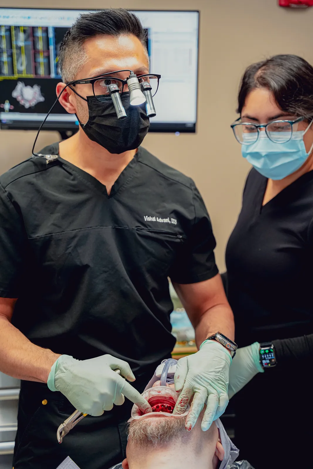 Dr. Vishal Advani and an assistant treating a patient