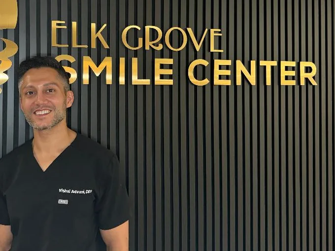 Dr. Vishal Advani in front of the Elk Grove Smile Center sign