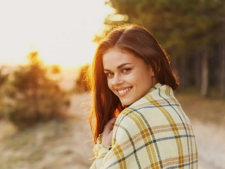 Smiling woman outdoors at sunset