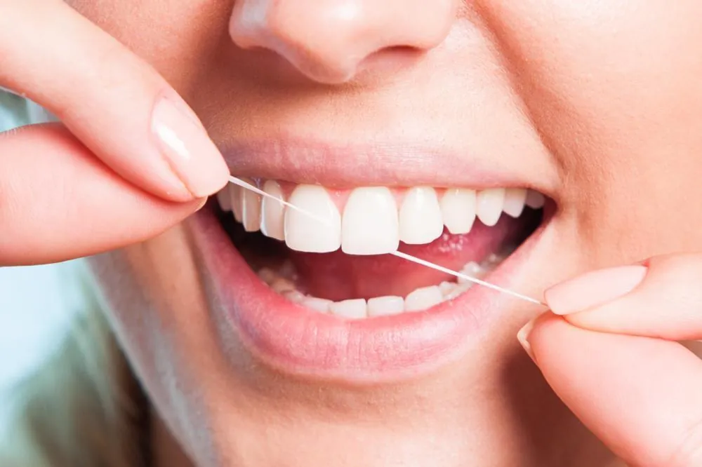 Close-up of flossing between healthy teeth