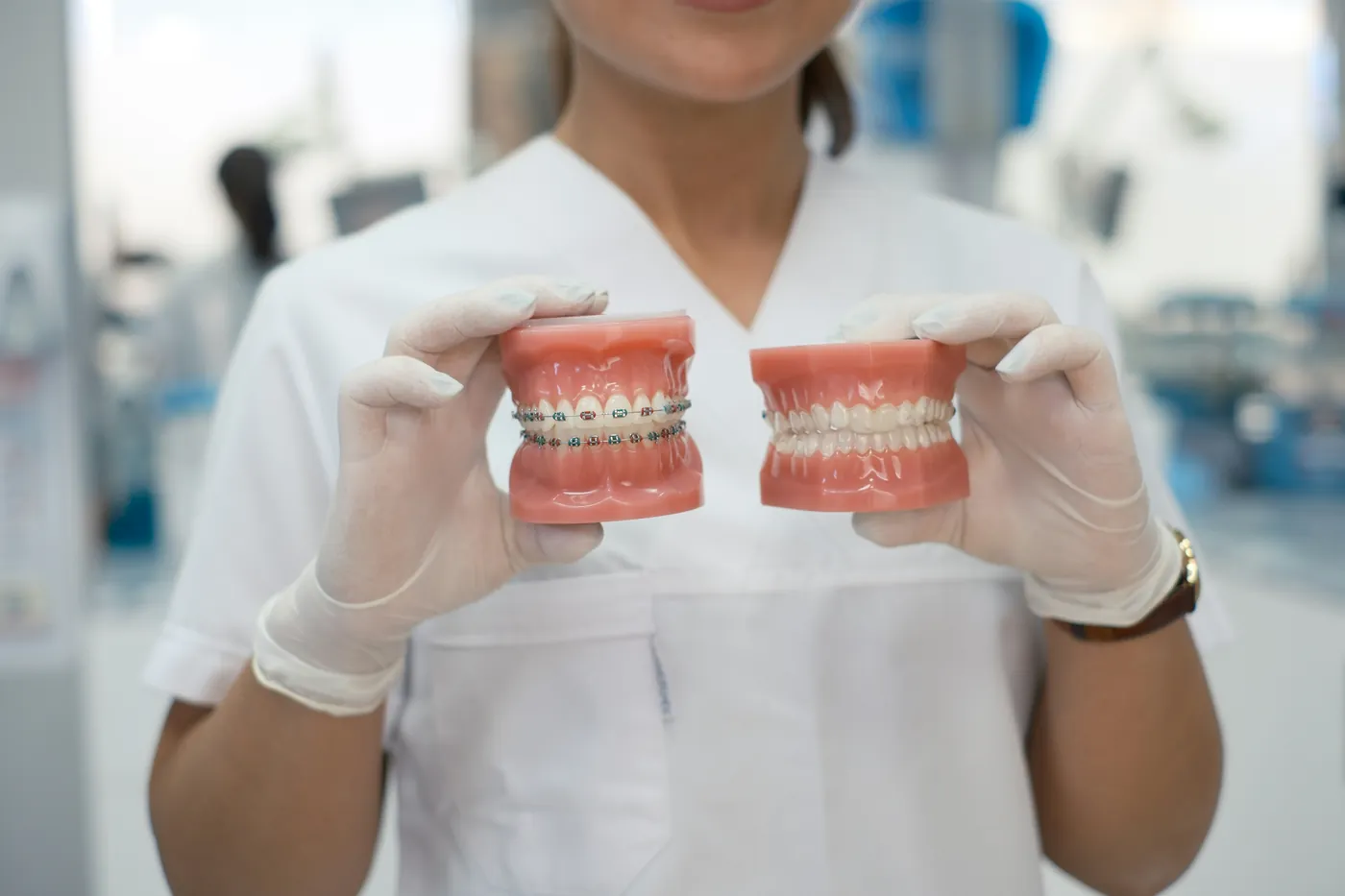 Dental professional holding upper and lower tooth models