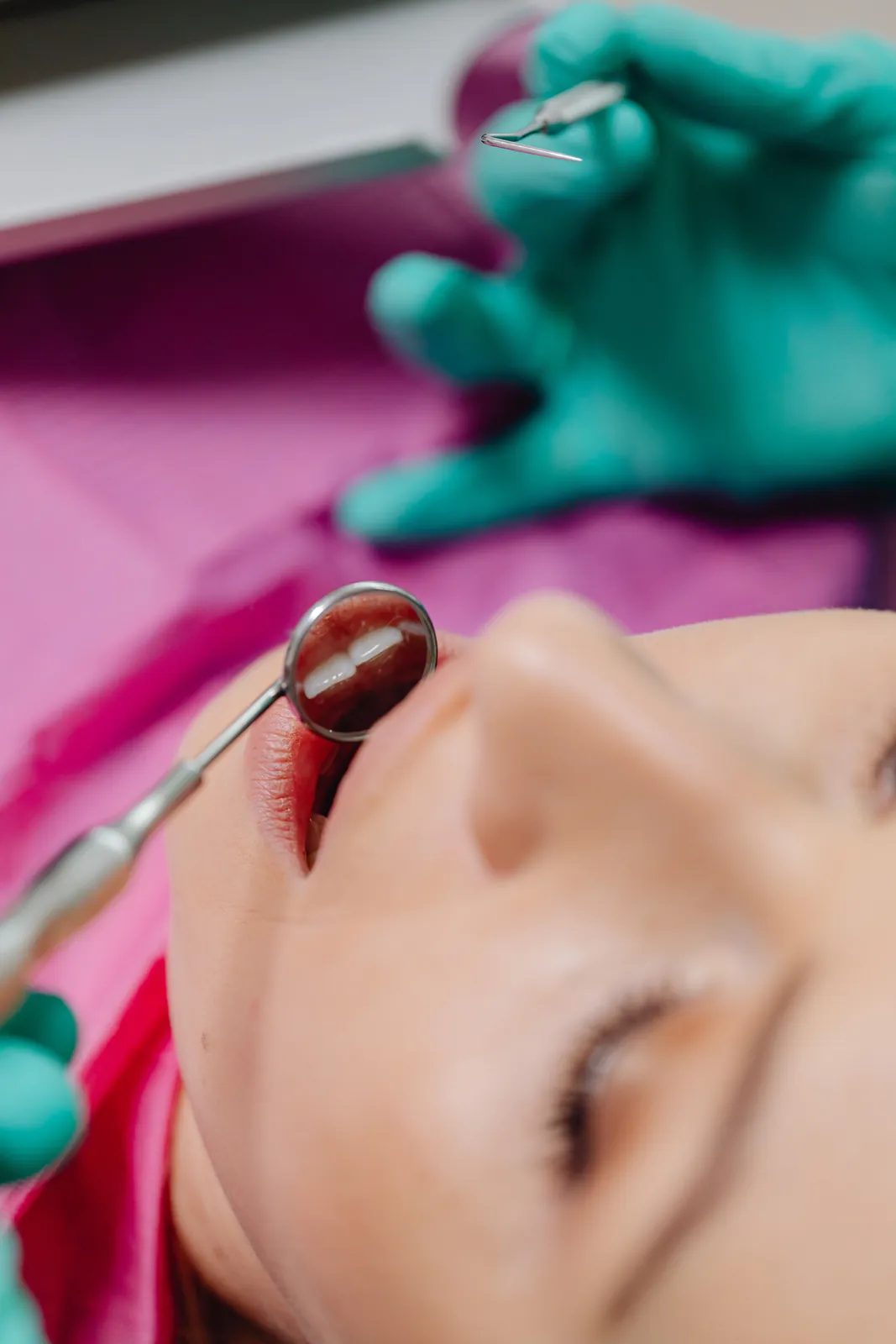 Dentist examining a woman’s smile with a dental mirror