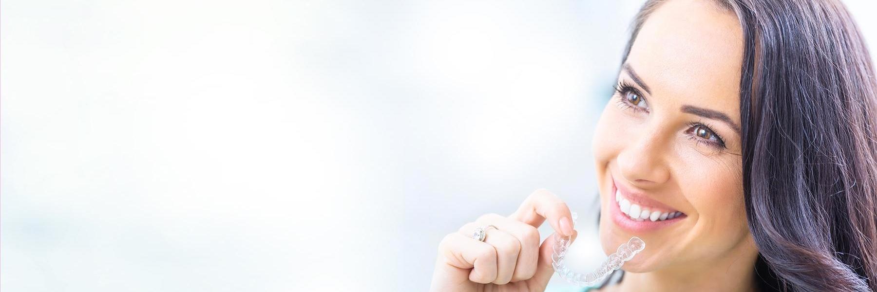 Lady holding Invisalign clear aligners at Elk Grove Smile Center