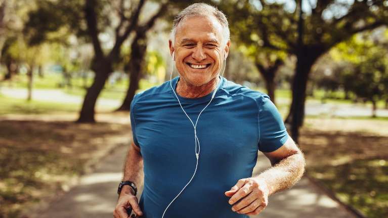Man jogging happily after getting dental crowns from Elk Grove village