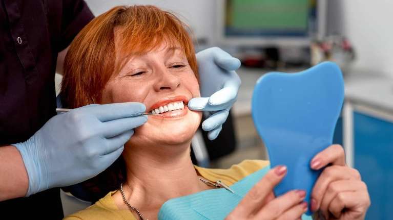 Lady looking herself in the mirror after getting implants in Elk Grove village, Illinois