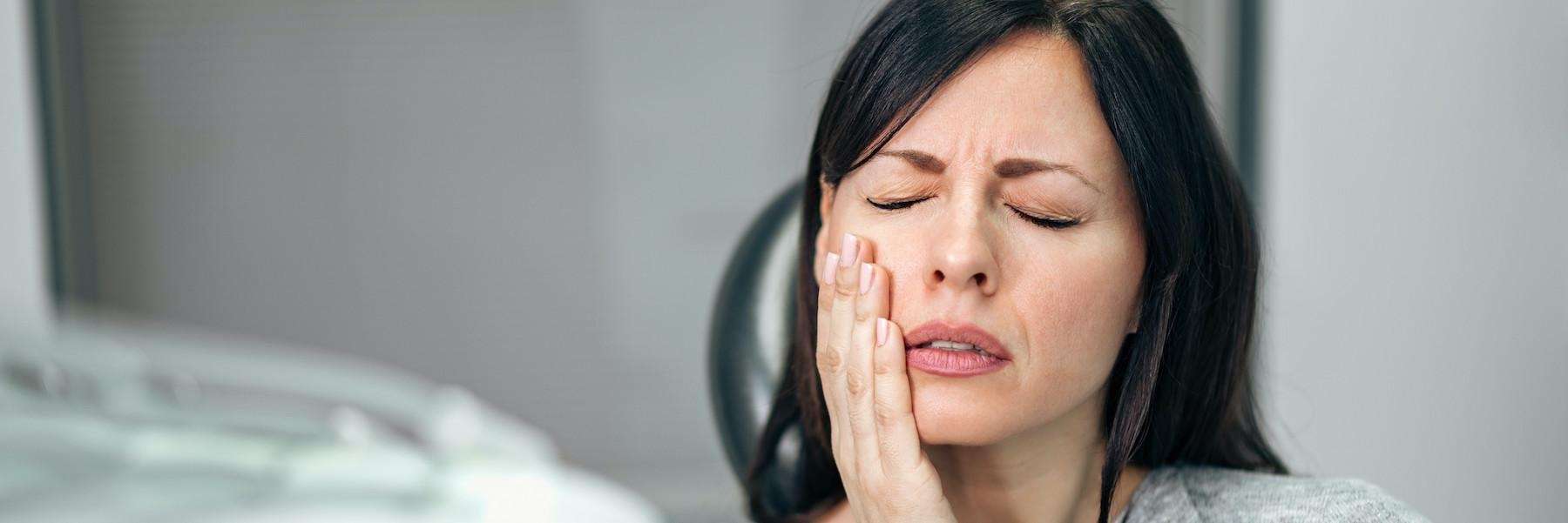 Lady holding her jaw due to migraines in Elk Grove village Illinois
