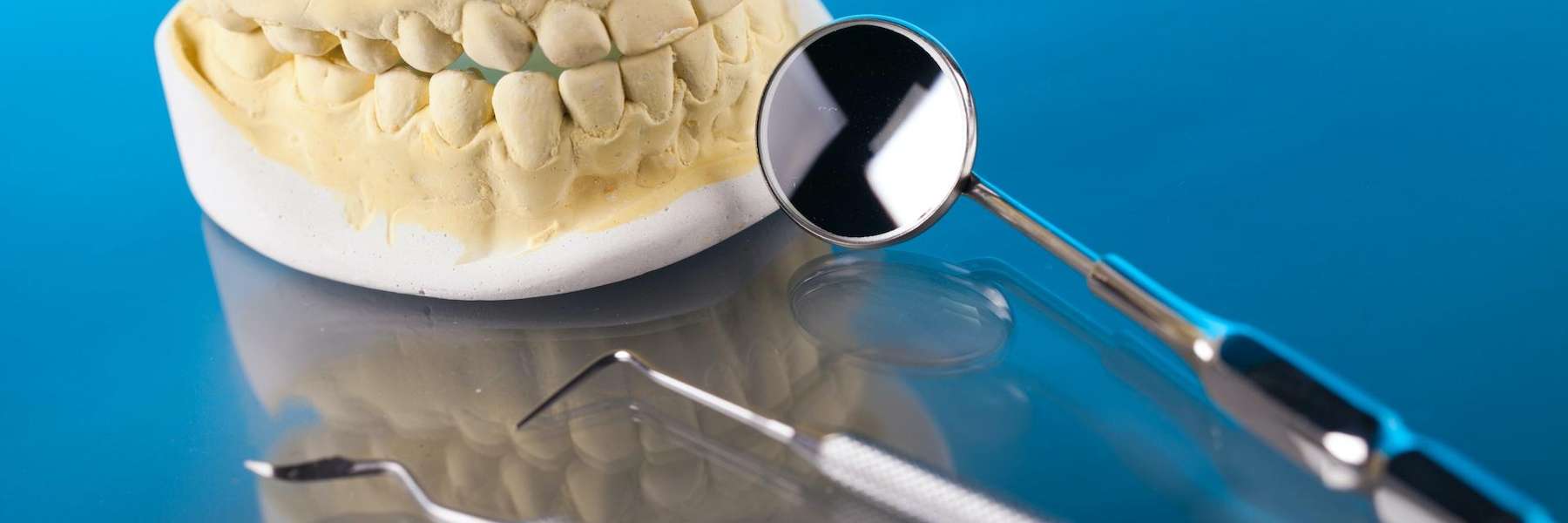 A picture of teeth extraction tools and a dental crown at Elk Grove Smile Center